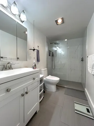 a bathroom with a double vanity sink toilet and shower