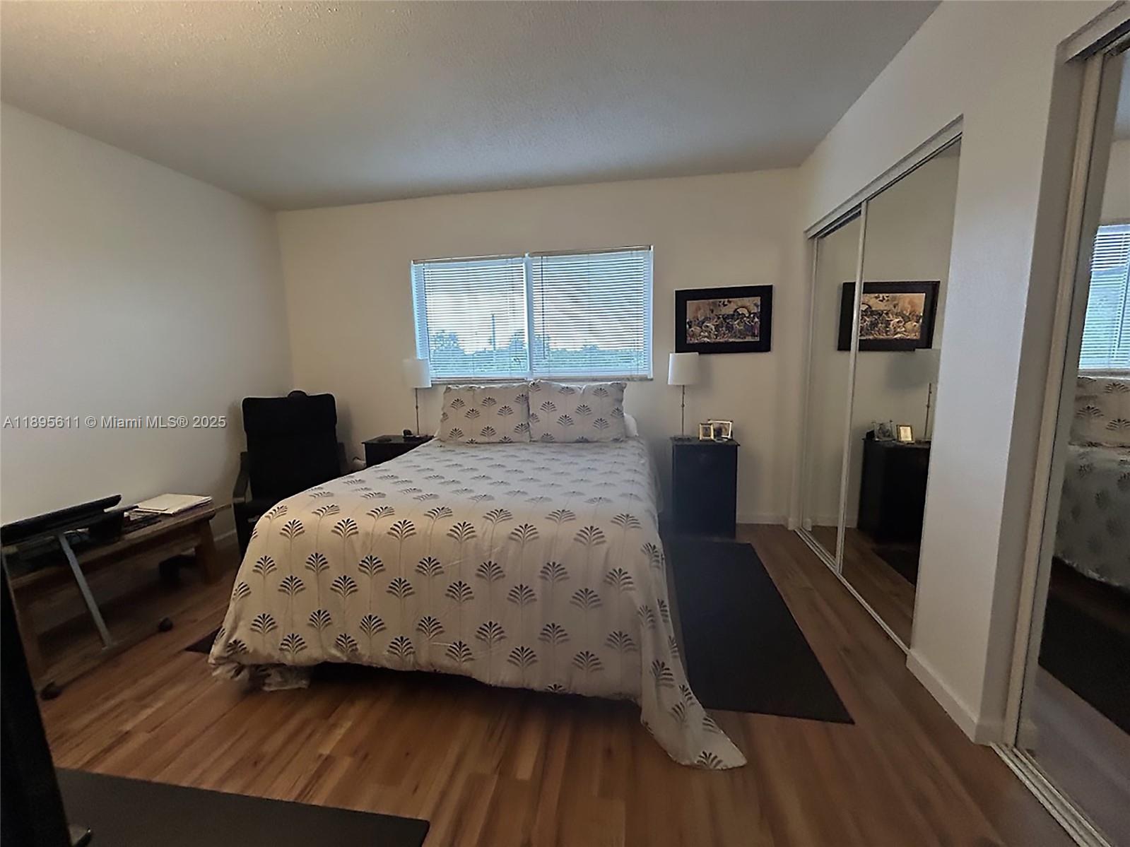 1400 Northeast 54th Street, Unit 306 Fort Lauderdale, FL 33334 - Photo 7 of 12 a bedroom with a bed and wooden floor