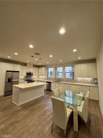 a living room with furniture a flat screen tv and kitchen view