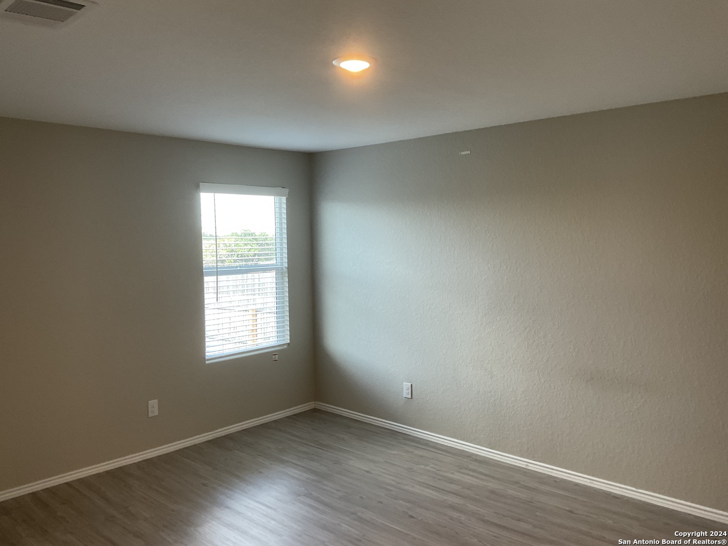 5813 Companion Loop Bulverde, TX 78163 - Photo 12 of 28 an empty room with wooden floor and windows