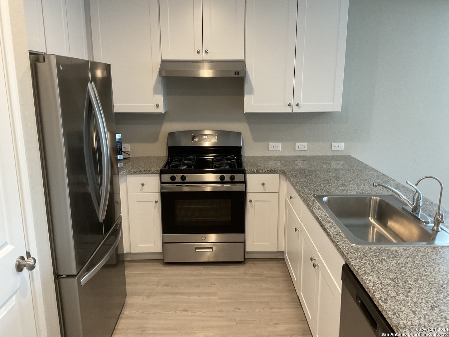 5813 Companion Loop Bulverde, TX 78163 - Photo 6 of 28 a kitchen with white cabinets and stainless steel appliances