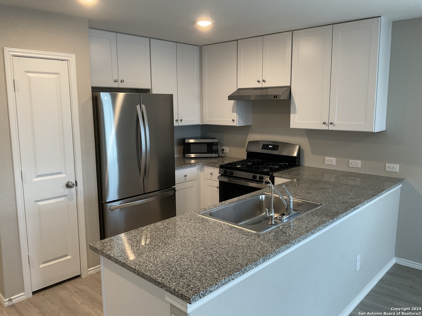 5813 Companion Loop Bulverde, TX 78163 - Photo 7 of 28 a kitchen with granite countertop a refrigerator and a sink