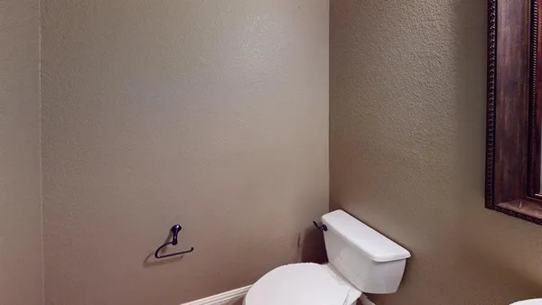 a white toilet sitting next to a white wall