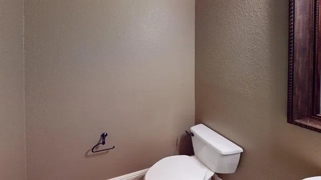 a white toilet sitting next to a white wall