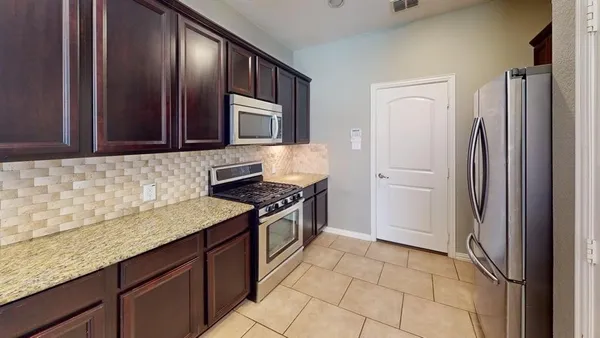 a kitchen with stainless steel appliances granite countertop a refrigerator and a sink