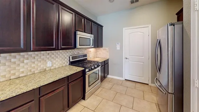 a kitchen with stainless steel appliances granite countertop a refrigerator and a sink