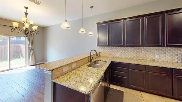 a kitchen with a sink a counter space and wooden cabinets
