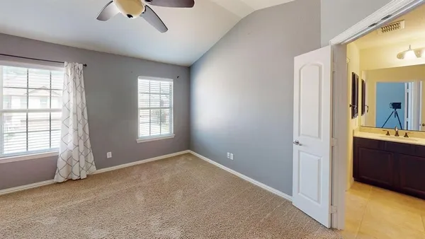 a view of an empty room with a window and bathroom