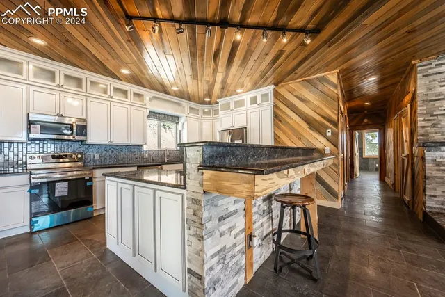 a kitchen with stainless steel appliances granite countertop a stove and a refrigerator