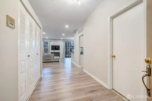 a view of a hallway view with wooden floor and a living room