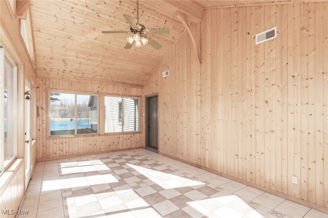 2866 South County Line Road Madison, OH 44057 - Photo 46 of 48 Unfurnished room featuring high vaulted ceiling, visible vents, wood walls, a ceiling fan, and wooden ceiling
