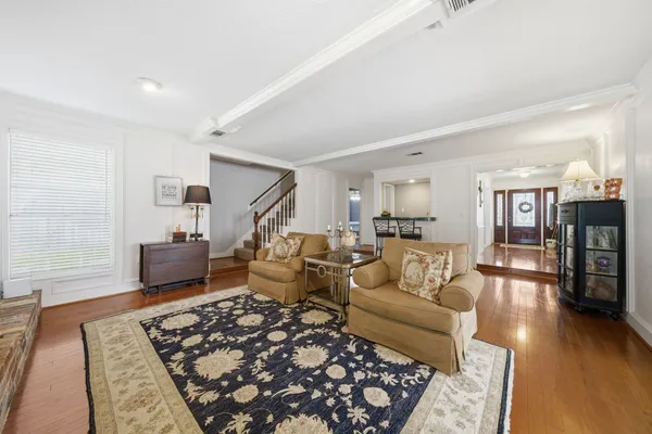a living room with furniture and wooden floor