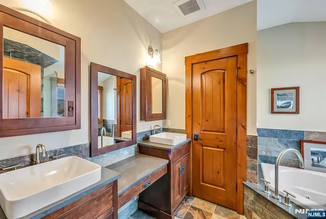a bathroom with 2 sink tub and a mirror