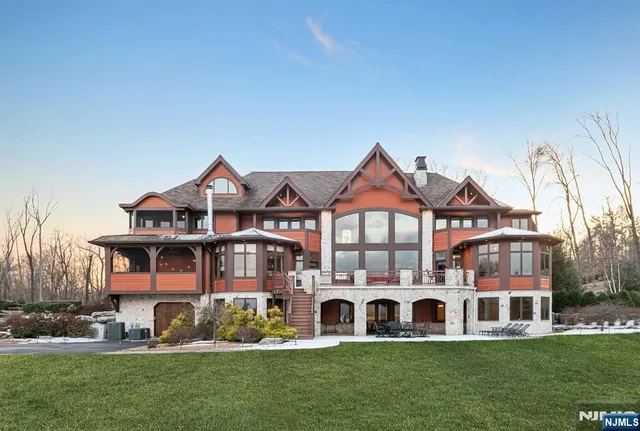 a view of a big house in a big yard with plants and large trees