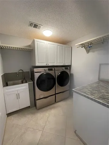 a utility room with cabinets washer and dryer