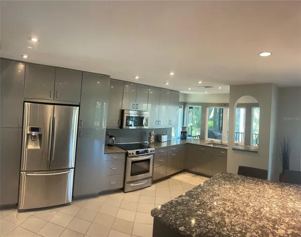 a kitchen with stainless steel appliances granite countertop a refrigerator sink and stove