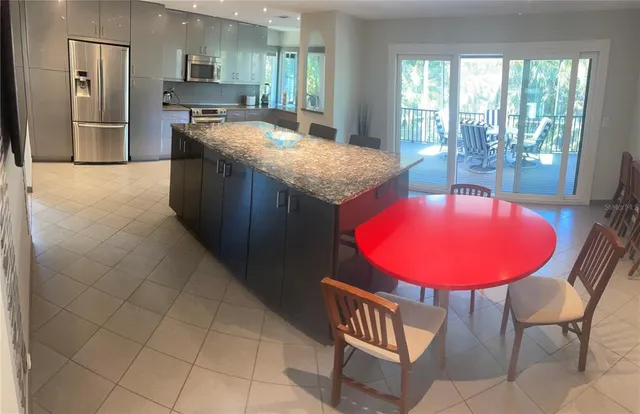 a kitchen with stainless steel appliances granite countertop a sink and a refrigerator