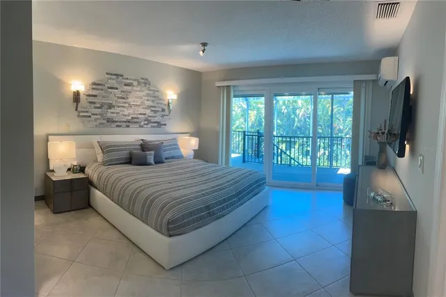 a bedroom with a large bed and a flat tv screen on dresser