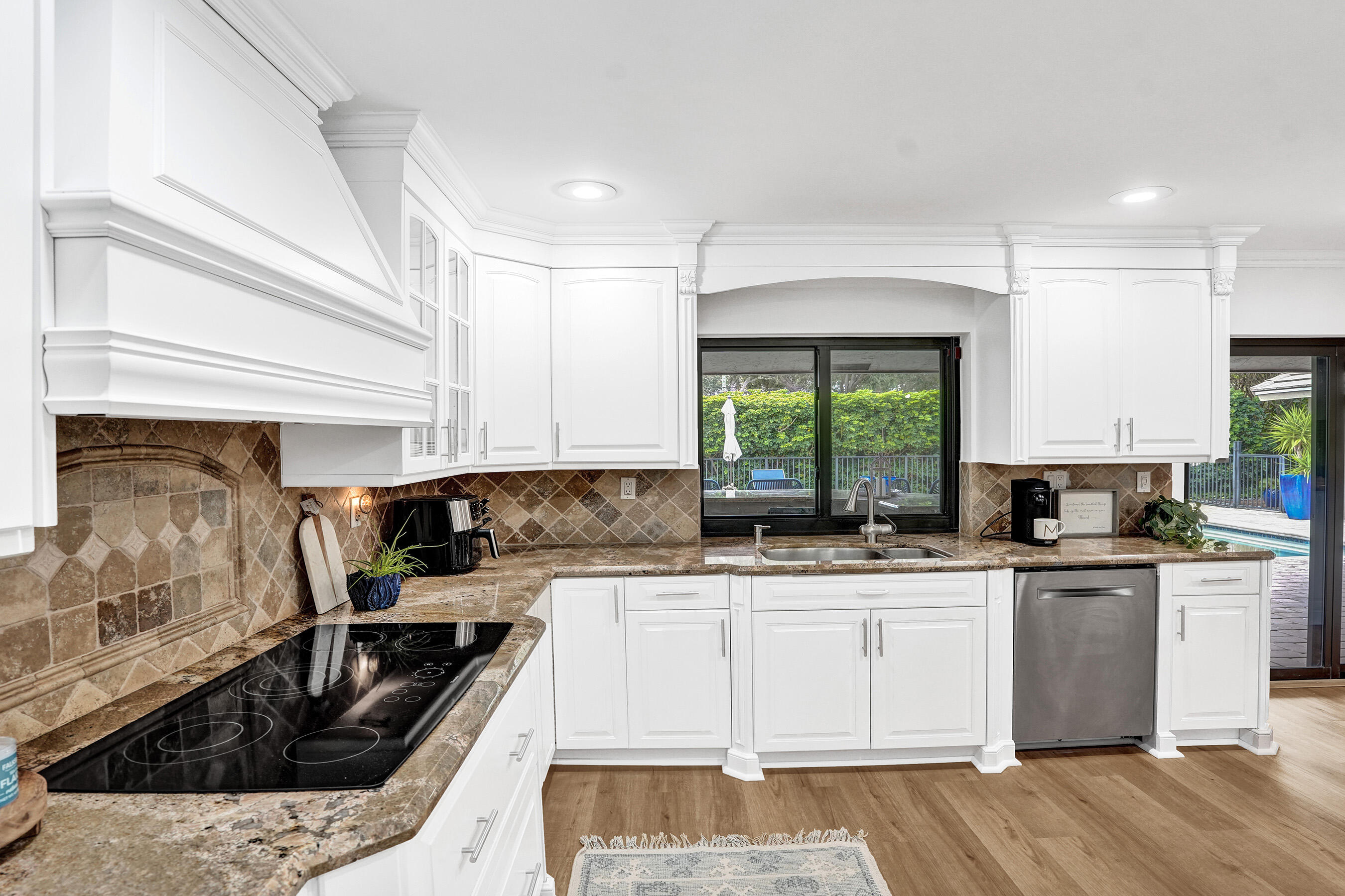 2413 Northwest 40th Circle Boca Raton, FL 33431 - Photo 19 of 66 a kitchen with a sink a stove and cabinets