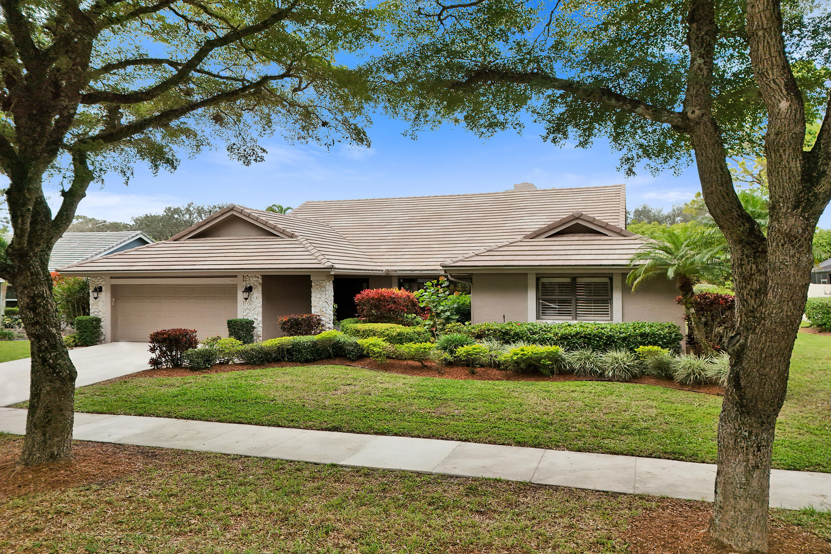 2413 Northwest 40th Circle Boca Raton, FL 33431 - Photo 3 of 66 a front view of a house with a garden