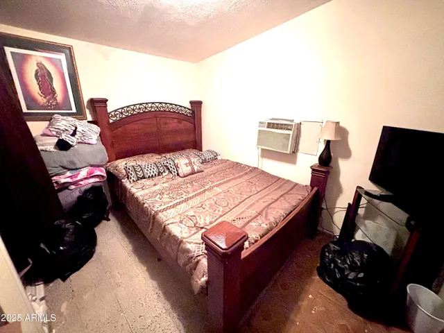 a bedroom with a bed a couch and dresser