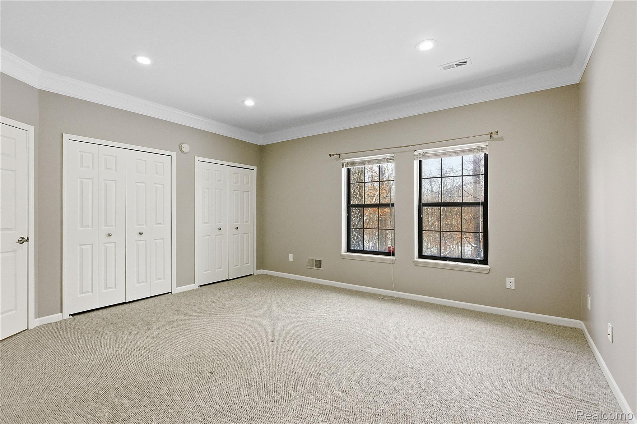 7154 Westchester Road West Bloomfield, MI 48322 - Photo 15 of 38 Unfurnished bedroom with multiple closets, crown molding, light carpet, and recessed lighting
