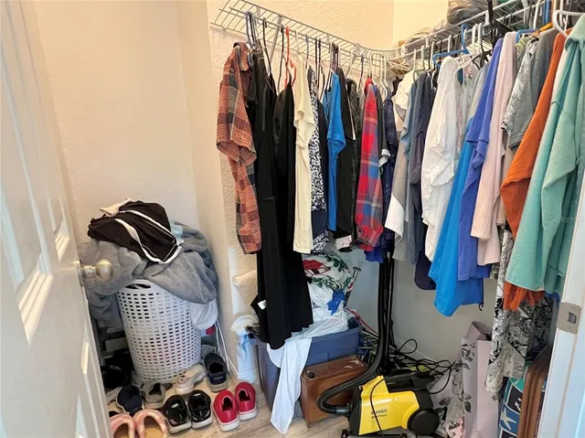 a view of walk in closet with clothes and shoes
