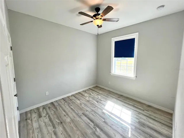 an empty room with a window and a ceiling fan
