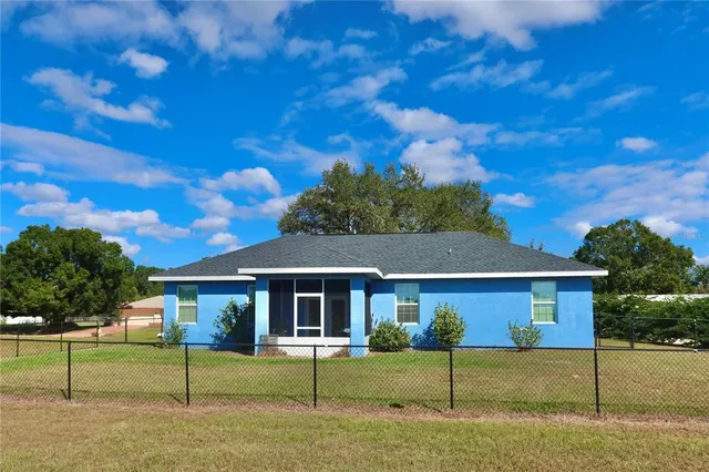 a view of a house with backyard and a tree