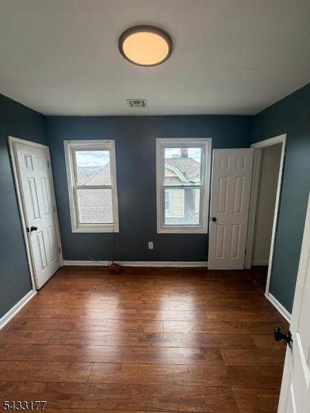166 Renner Avenue, Unit 3 Newark, NJ 07112 - Photo 17 of 24 an empty room with wooden floor and windows