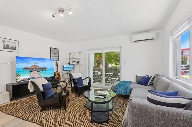 a living room with stainless steel appliances furniture a rug and a view of kitchen