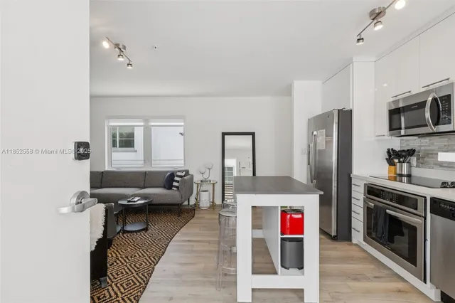a kitchen with stainless steel appliances a refrigerator sink and microwave