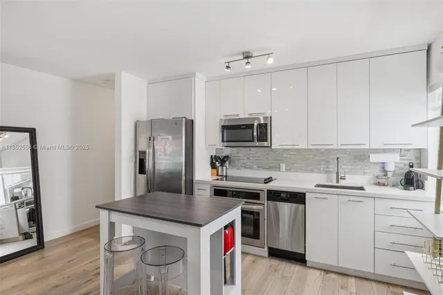a kitchen with stainless steel appliances a refrigerator sink and microwave