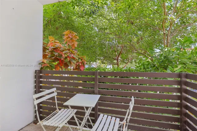 a view of a balcony with two chairs and a potted plant