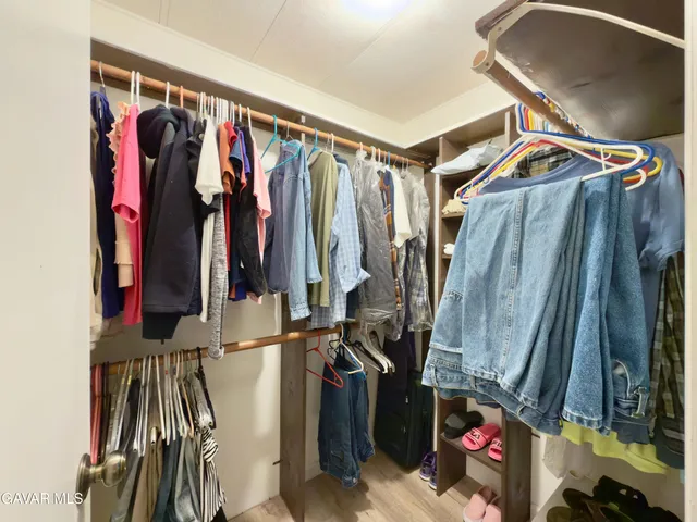 a view of walk in closet with clothes and shoes