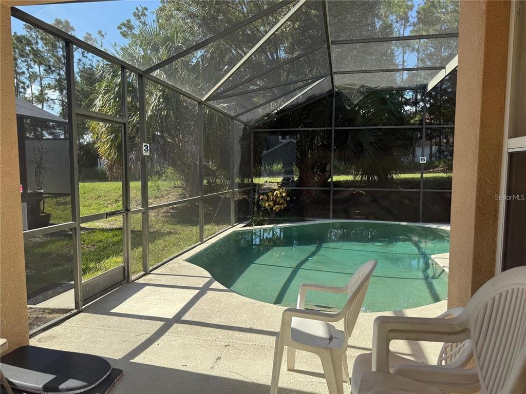 525 Corvina Drive Davenport, FL 33897 - Photo 14 of 15 a view of a chairs and table in the patio with a backyard
