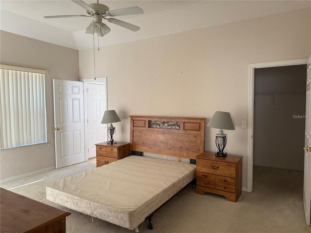 525 Corvina Drive Davenport, FL 33897 - Photo 7 of 15 a bedroom with a bed and a chandelier