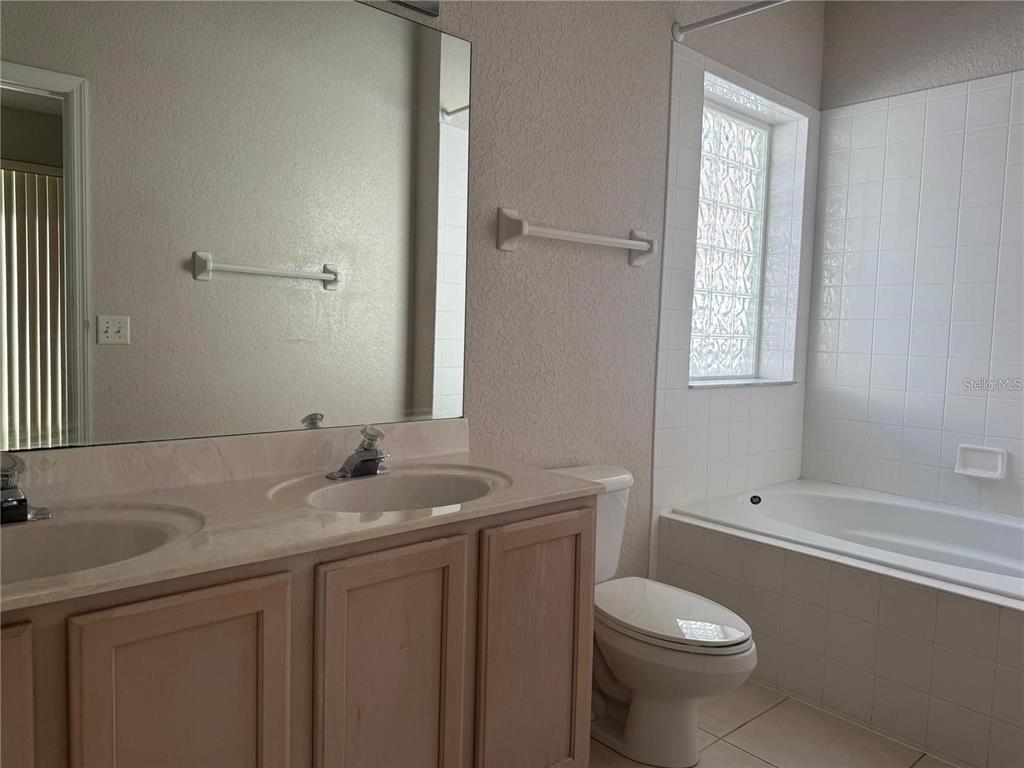 525 Corvina Drive Davenport, FL 33897 - Photo 8 of 15 a bathroom with a granite countertop sink toilet and shower