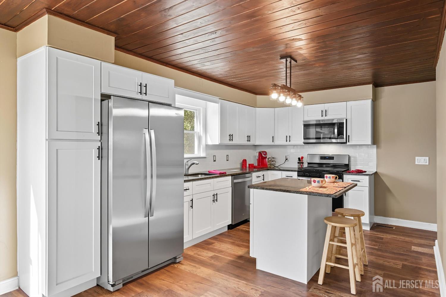 2092 Main Road Newfield, NJ 08344 - Photo 7 of 29 a kitchen with stainless steel appliances granite countertop a refrigerator a stove a sink dishwasher and white cabinets with wooden floor