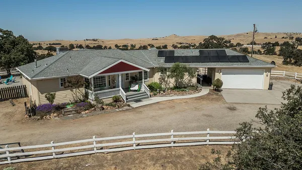 a kitchen with stainless steel appliances kitchen island granite countertop a table chairs and a refrigerator