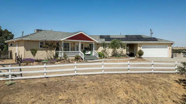 a kitchen with stainless steel appliances kitchen island granite countertop a table chairs and a refrigerator