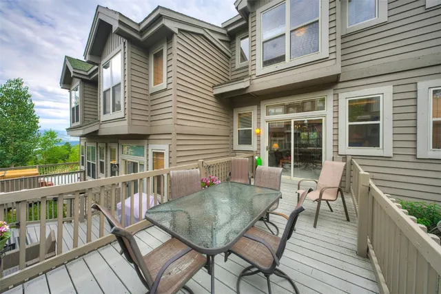 a view of a house with a deck and furniture