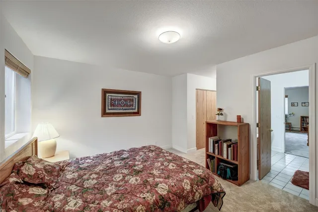 a bedroom with a bed and a lamp on dresser