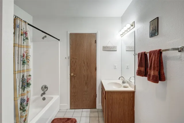 a bathroom with a sink a mirror a shower and a bathtub