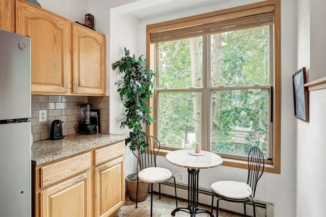 a kitchen with granite countertop white cabinets and dining table