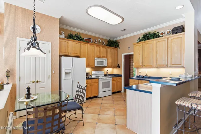 a kitchen with stainless steel appliances granite countertop a stove top oven a sink dishwasher and a refrigerator with wooden floor