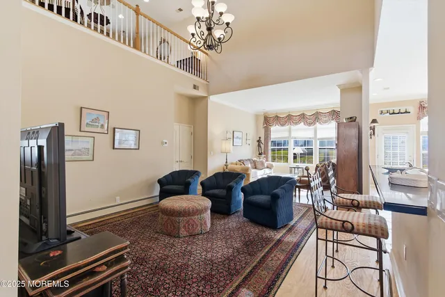 a living room with furniture a chandelier and a flat screen tv