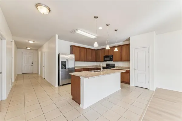 a kitchen with kitchen island a counter top space appliances and cabinets