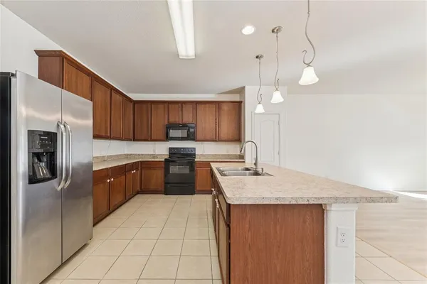 a kitchen with a sink a counter space appliances and cabinets