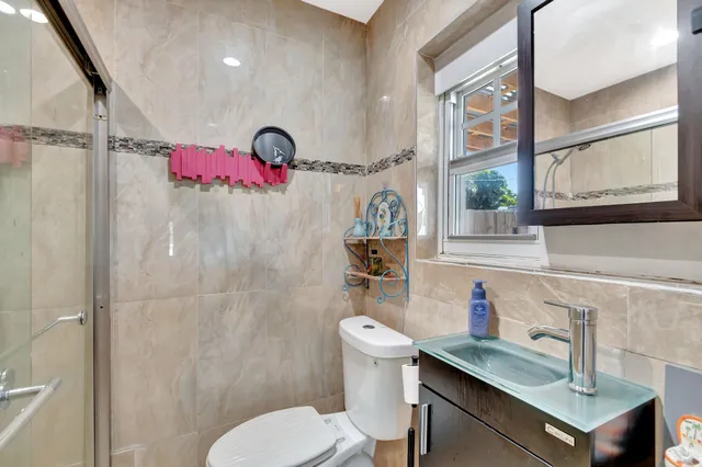 a bathroom with a sink mirror vanity and toilet
